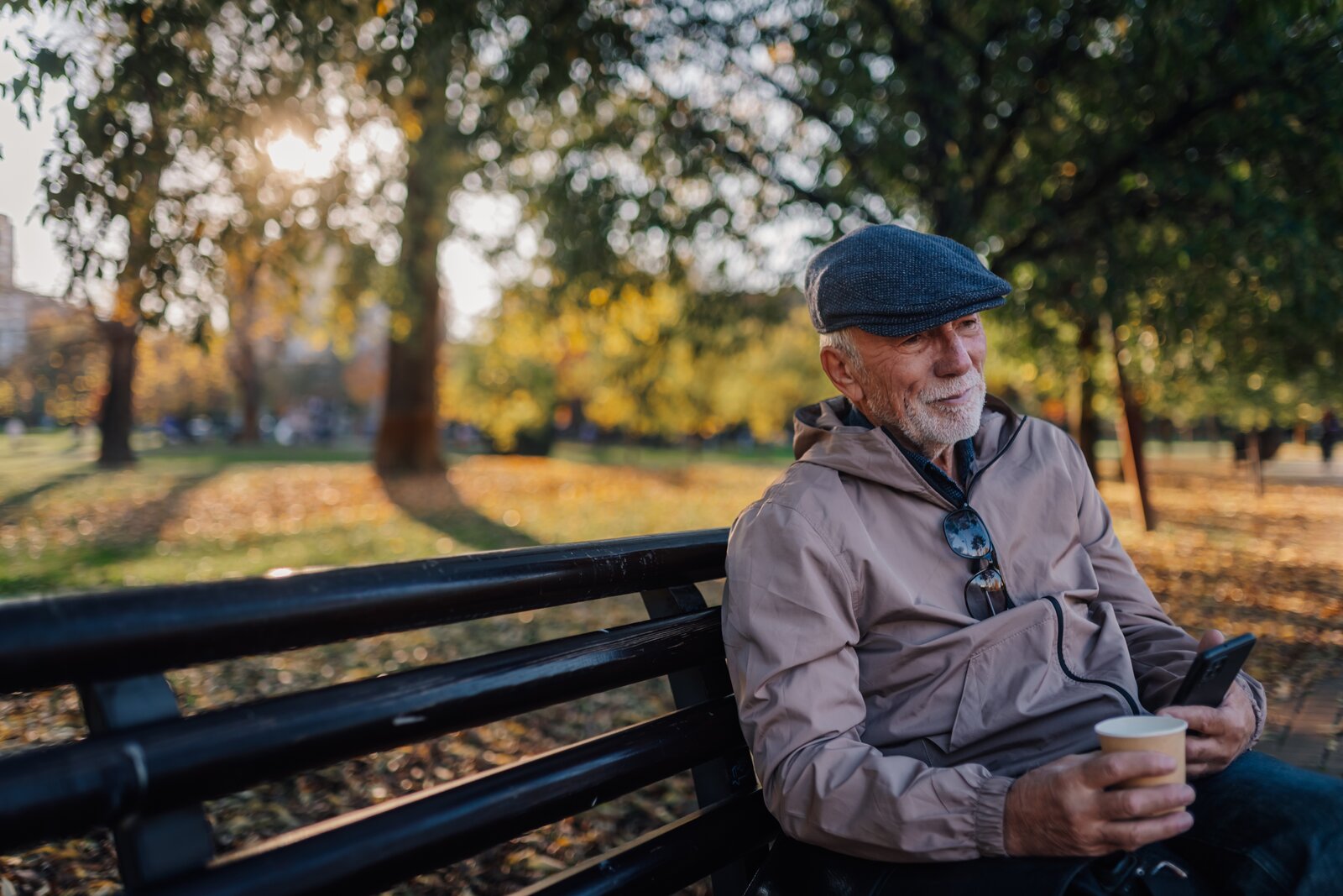 Elderly man on park bench in autumn