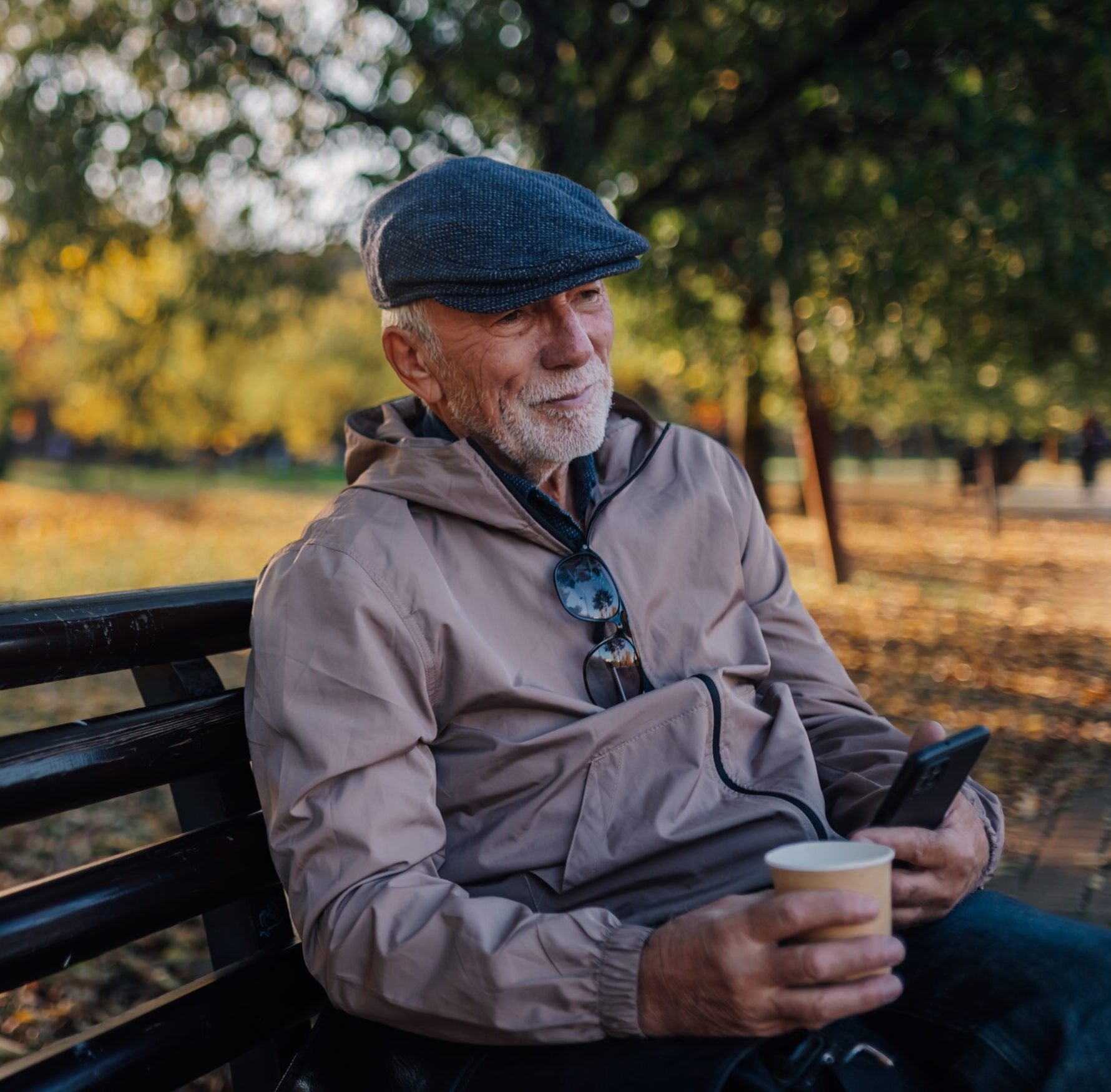 Elderly man on park bench in autumn