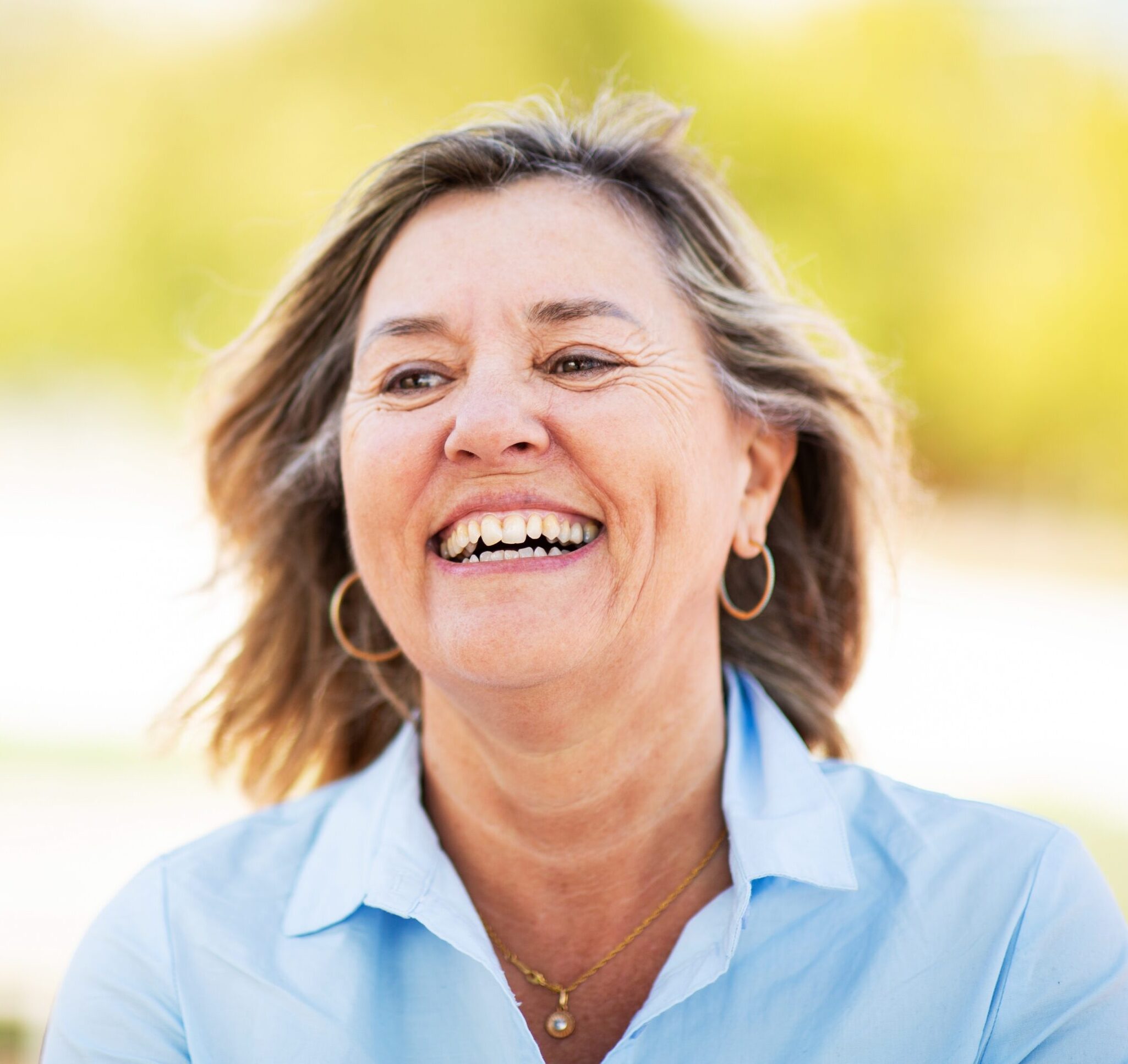 Smiling middle-aged woman outdoors in natural light
