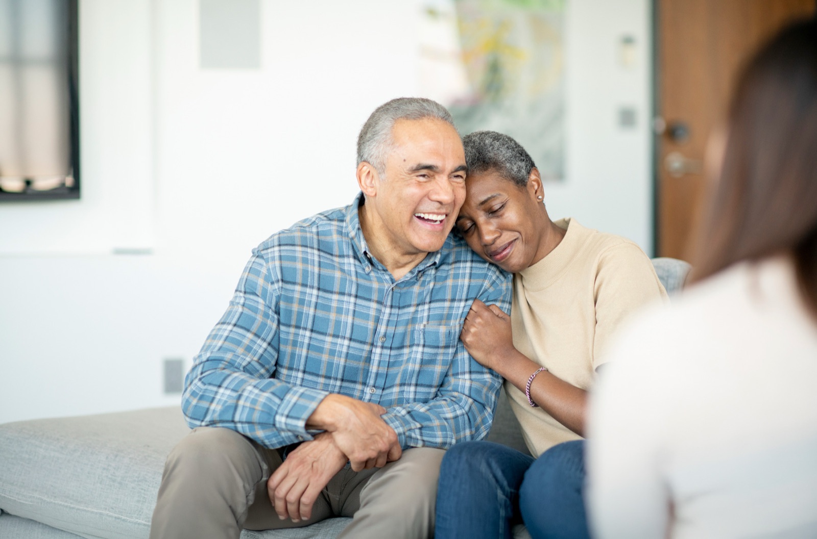 Smiling senior couple embracing on living room couch