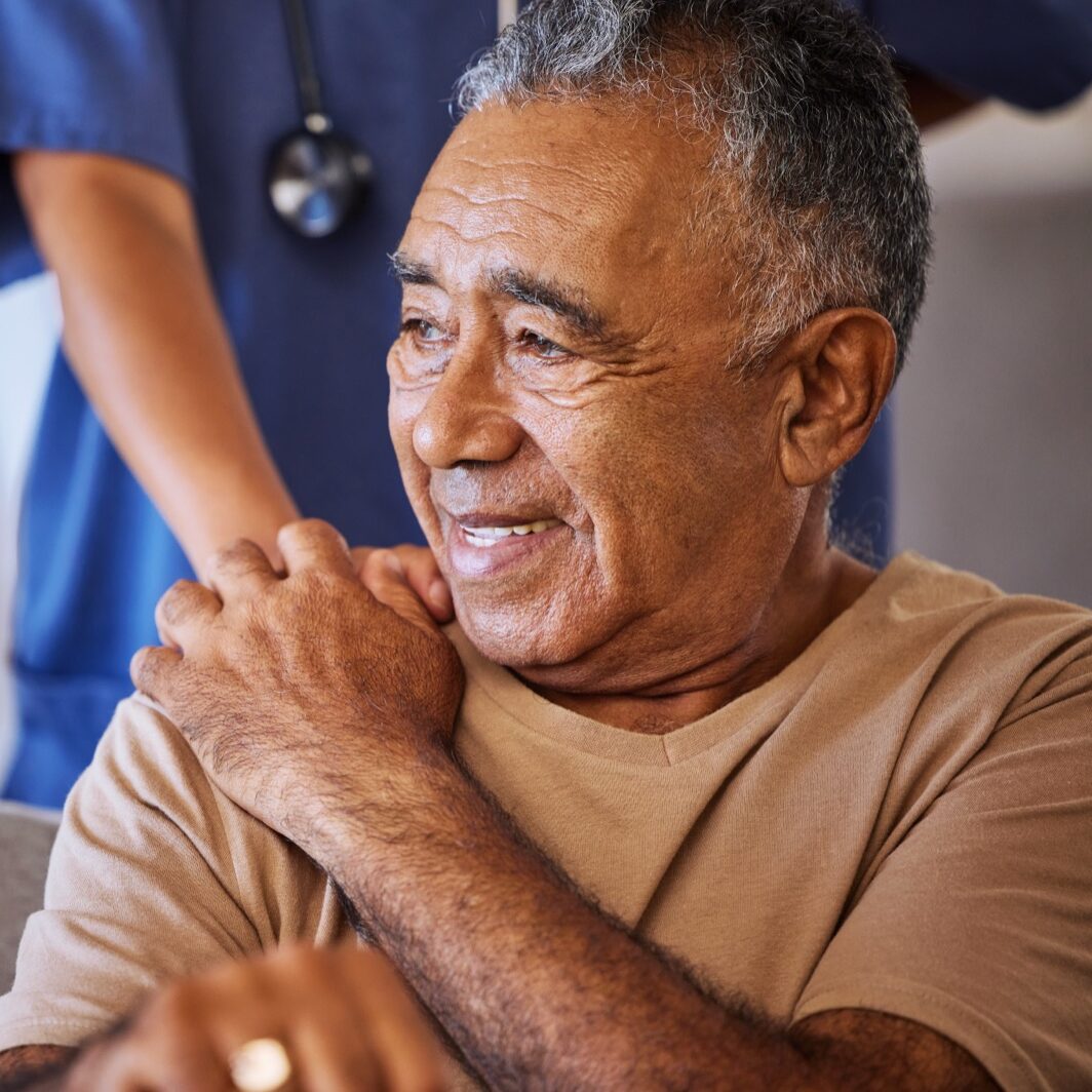 Elderly man with shoulder pain assisted by nurse