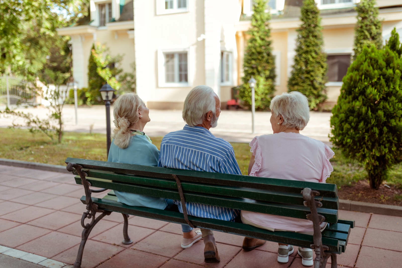 Three seniors sitting on park bench outdoors