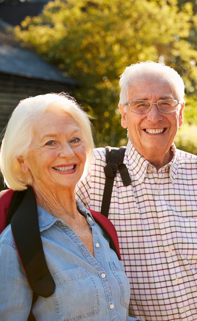 Smiling seniors hiking together outdoors in sunny park