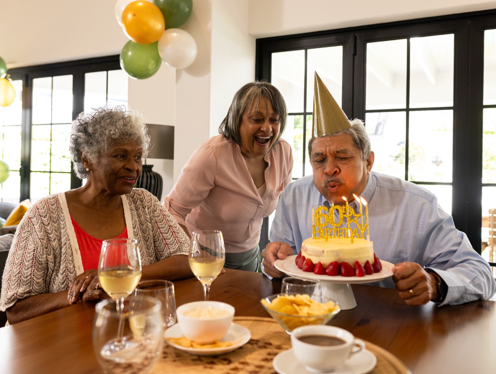 Man blowing candles on 60th birthday cake