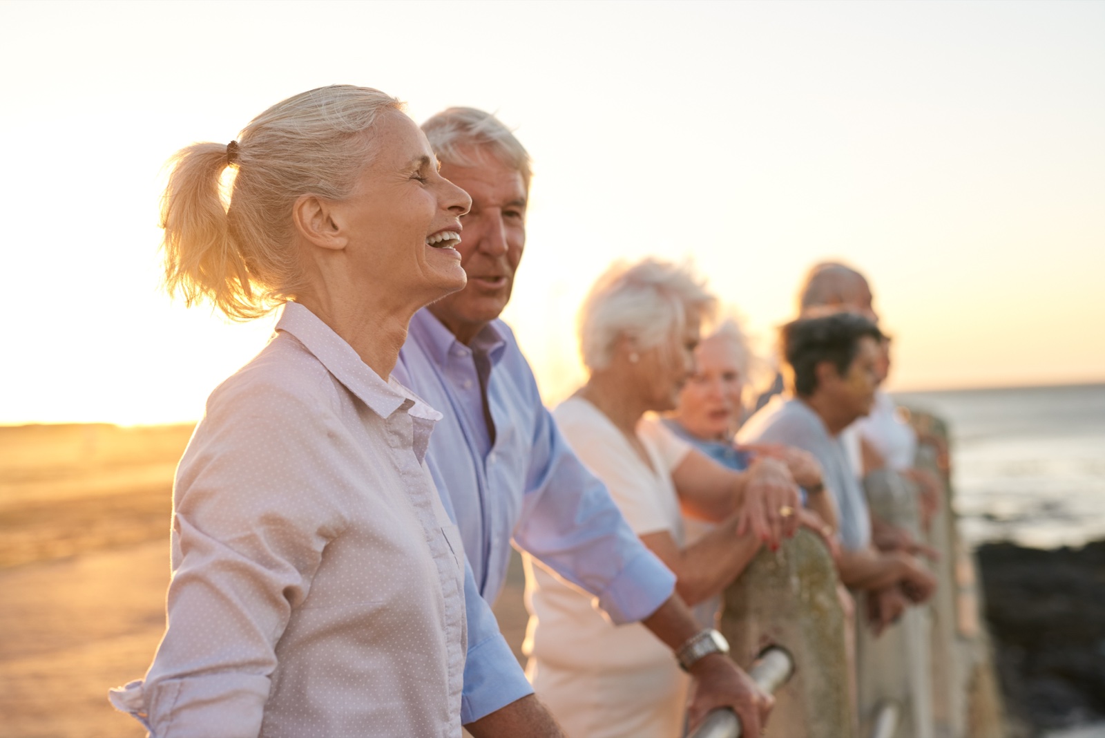 Group of seniors enjoying sunset by the beach